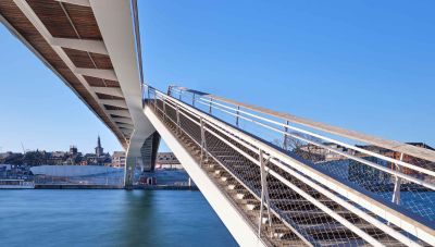 Slanke, transparente passerelle over de Maas